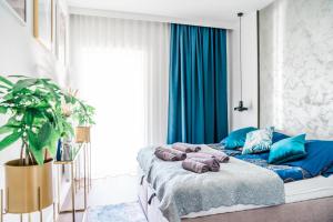 Un dormitorio con una cama con almohadas azules. en Nautica 5 en Giżycko