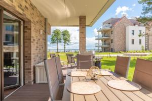 un patio con mesa y sillas en una terraza en Nautica 5, en Giżycko