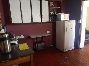 uma cozinha com um frigorífico branco e uma mesa em Orkkowasi backpackers em Arequipa