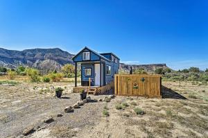 a tiny house in the desert with mountains in the background at Boho Bliss Tiny Home with Fireplace, Fire Pit in Towaoc