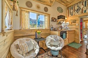 a living room with two chairs and a kitchen at Boho Bliss Tiny Home with Fireplace, Fire Pit in Towaoc