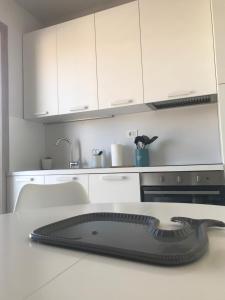a kitchen with white cabinets and a black appliance on a counter at SeSil Amare in Porto Recanati