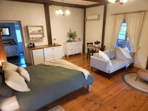 a bedroom with a bed and a couch and a table at Marananga Cottages in Marananga