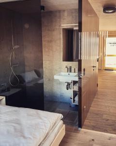 Habitación con baño con cama y lavabo. en Wasserfall Apartment Waldblick en Mellau