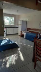 Pokój z sypialnią z łóżkiem i kuchnią w obiekcie Pousada 4 Estações Campeche w mieście Florianópolis