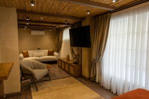 a living room with a bed and a couch and a television at ASHA ALAÇATI in Çeşme