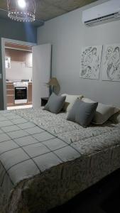 a bedroom with a large bed and a kitchen at MIRACERROS Departamento en Salta in Salta