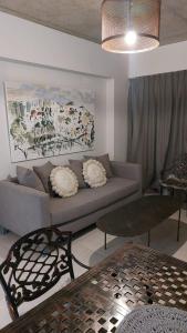 un soggiorno con divano e un dipinto sul muro di MIRACERROS Departamento en Salta a Salta