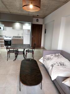 a living room with a bed and a table and a kitchen at MIRACERROS Departamento en Salta in Salta
