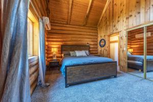 - une chambre avec un lit dans une cabane en rondins dans l'établissement Rowland Log Cabin home, à Lyle
