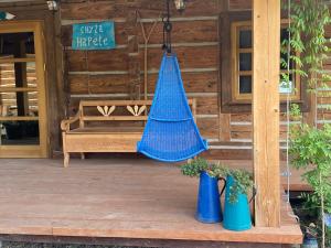 eine blaue Hängematte auf einer Veranda mit einer Bank in der Unterkunft Chyża Hapełe in Zatwarnica