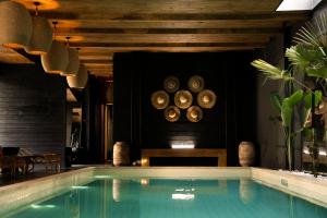 a swimming pool in a room with wooden ceilings at Esquisse Design Hotel in Telavi