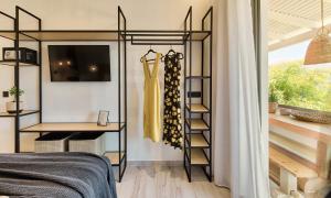 a bedroom with a closet with a dress on a shelf at Nomas Living in Kalamaki