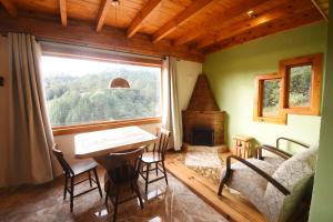 a room with a table and chairs and a window at Chalé Colibris in Camanducaia