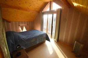 a bedroom with a bed in a room with a window at Chalé Colibris in Camanducaia