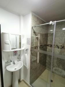 een badkamer met een wastafel en een glazen douche bij Hostal Raatid Manchy in San Andrés