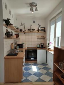 uma cozinha com um piso xadrez azul e branco em garncarska6 em Gdansk