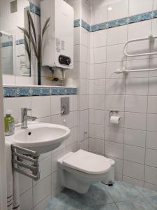 a white bathroom with a toilet and a sink at garncarska6 in Gdańsk