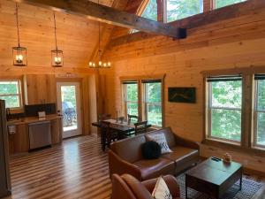 a living room and kitchen in a log cabin at windrock ridge - Ethan in Oak Ridge