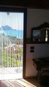 a door to a room with a view of a balcony at Casa Plaja degli Uccelli in Cefalù