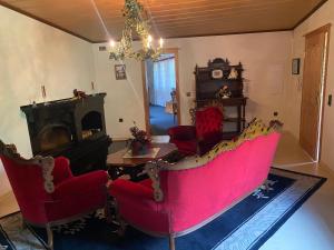 a living room with a red couch and chairs at Chalet am See in Sontra