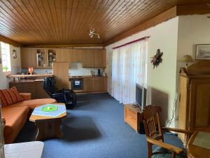 a living room with a couch and a kitchen at Chalet am See in Sontra