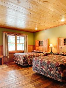 a bedroom with two beds and a wooden ceiling at Cranberry Inn in Mercer