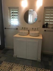 a bathroom with two sinks and a mirror at KokohauBungalows in Santa Veronica