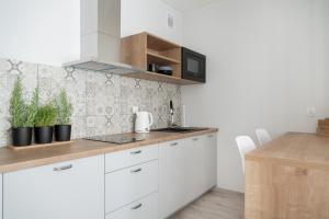 una cocina con armarios blancos y una barra con plantas en Scandinavian en Szczecin