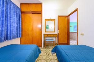 a room with two beds and a desk and a mirror at Palmasol Apartamentos in Puerto Rico de Gran Canaria