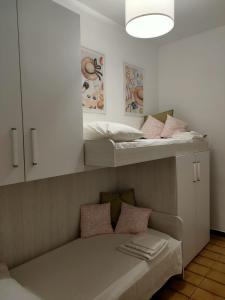 a room with two bunk beds and a bench with pillows at Victory house in Lido di Ostia
