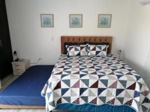 1 dormitorio con 1 cama con edredón en Hostal Raatid Manchy, en San Andrés