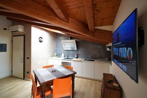 a kitchen with a table and a tv in a room at Stupenda mansarda dotata di tutti i comfort! in Brescia