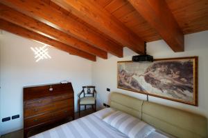 a bedroom with a bed and a painting on the wall at Stupenda mansarda dotata di tutti i comfort! in Brescia