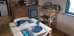 una pequeña cocina con una mesa con platos azules. en A l'ombre du prunier, en Licques