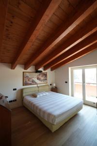 1 dormitorio con 1 cama grande y techo de madera en Stupenda mansarda dotata di tutti i comfort! en Brescia