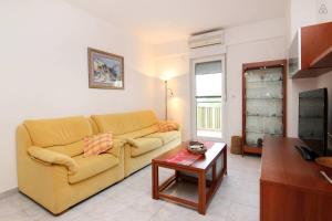 uma sala de estar com um sofá amarelo e uma mesa em Apartment Happy Day em Split