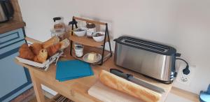 una mesa con un poco de pan y una tostadora en ella en A l'ombre du prunier, en Licques