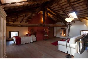 een slaapkamer met een bed en een bank in een kamer bij Affittacamere Valnascosta in Faedis