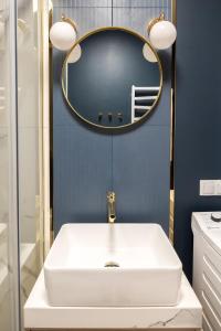 a bathroom with a white sink and a mirror at Elegant Junior in Szczecin