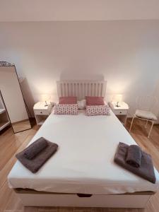 a bedroom with a large white bed with two towels on it at Holiday Hanna’s House in Valencia