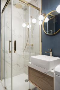 a bathroom with a shower with a sink and a mirror at Elegant Junior in Szczecin
