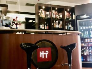 a bar with two black chairs in front of a counter at Hotel PentHouse in Perugia