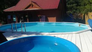 a large blue swimming pool with a red roof at Willa Skrzat in Danowskie