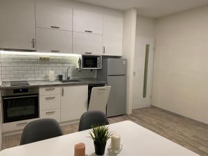 a kitchen with white cabinets and a table and chairs at Green park Sandanski in Sandanski