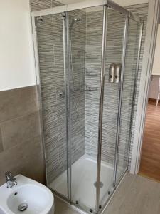 a shower with a glass door next to a sink at Villa Vittoria in Stresa