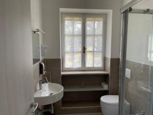 a bathroom with a sink and a toilet and a window at Villa Vittoria in Stresa