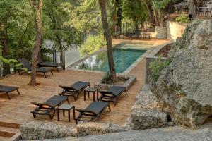 - un groupe de chaises assises sur une terrasse en bois à côté d'une piscine dans l'établissement Umani Hotel - Free Beach - Free Parking, aux Sables d'or