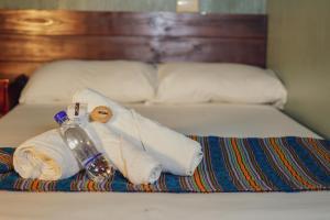 Una cama con toallas y una botella de agua. en POSADA SAN FRANCISCO 