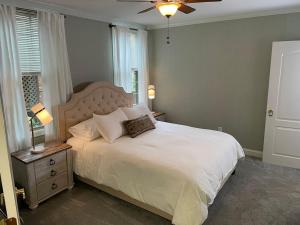 a bedroom with a bed with a white bedspread and a ceiling fan at The Millhouse Downtown Chester in Chester